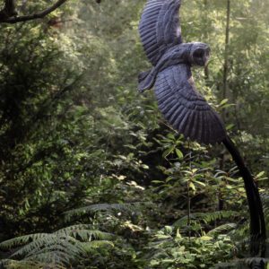 Fine Art Print - An owl in flight sculpture with a backlit glow from the sun through the dappled ferns.